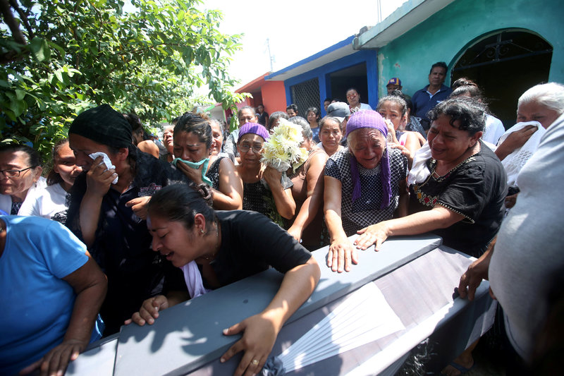 People participate in the burial of a victim of the earthquake that struck in Juchitan