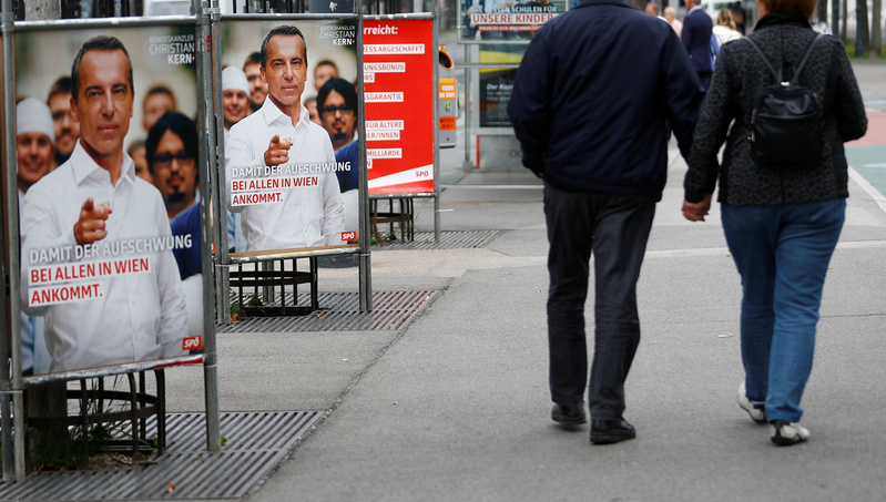 People walk past election campaign posters of Social Democrats in Vienna