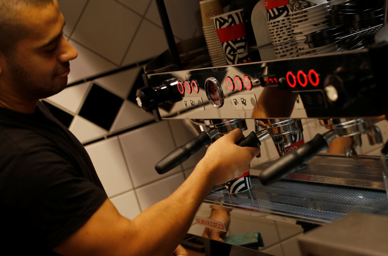 A EU citizen poses for a photograph in the cafe where he works in London