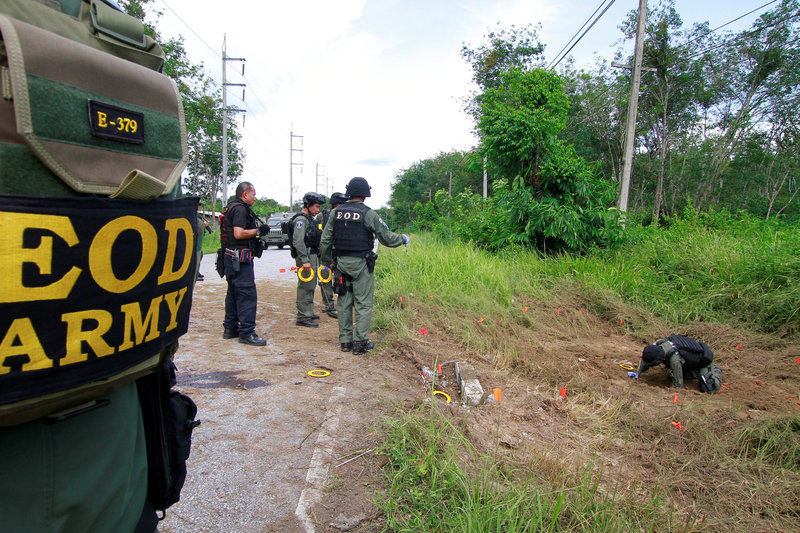 Military personnel check the place where a roadside bomb blast occurred in the southern province Malay Muslim province of Yala