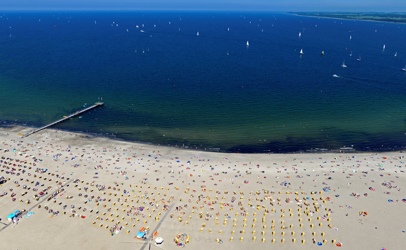FILE PHOTO: People sunbathe at a beach in Travemuende at the Baltic Sea