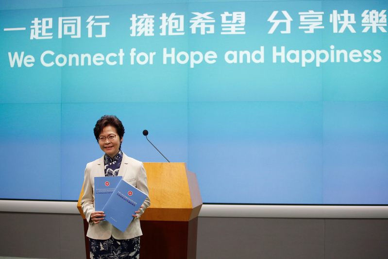 Hong Kong Chief Executive Carrie Lam poses with copies of her policy speech in Hong Kong