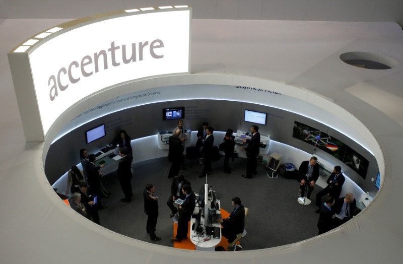 FILE PHOTO: Visitors look at devices at Accenture stand at the Mobile World Congress in Barcelona
