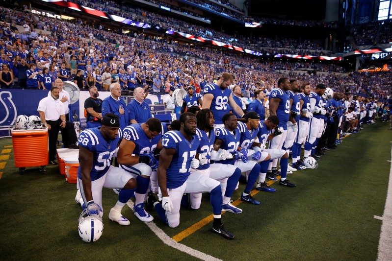 FILE PHOTO: Indianapolis Colts players kneel during the playing of the National Anthem before the game against the Cleveland Browns at Lucas Oil Stadium in Indianapolis