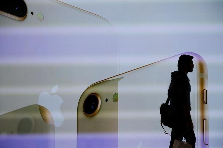 A customer walks past a large screen at the new Apple Visitor Center in Cupertino