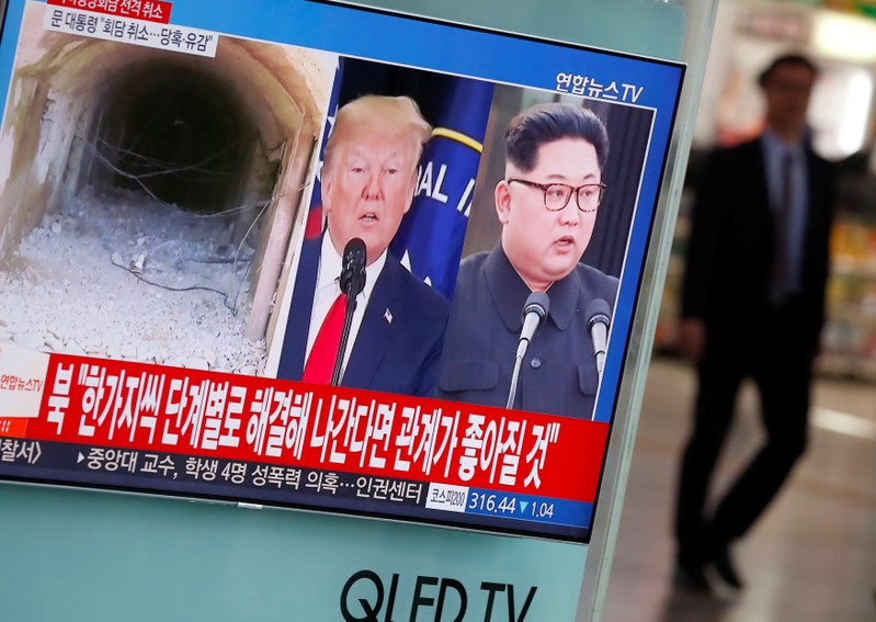 A man walks past a TV broadcasting a news report on a cancelled summit between the U.S. and North Korea, in Seoul