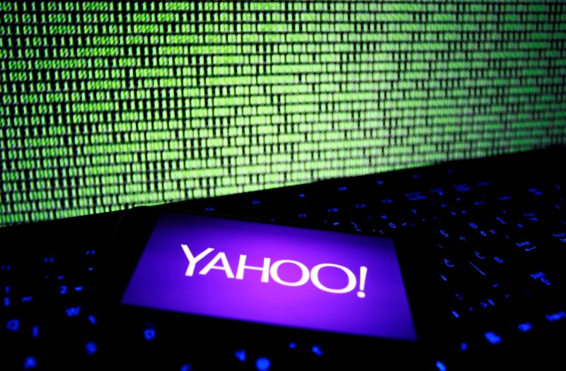A photo illustration shows a Yahoo logo on smartphone in front of a displayed cyber code and keyboard