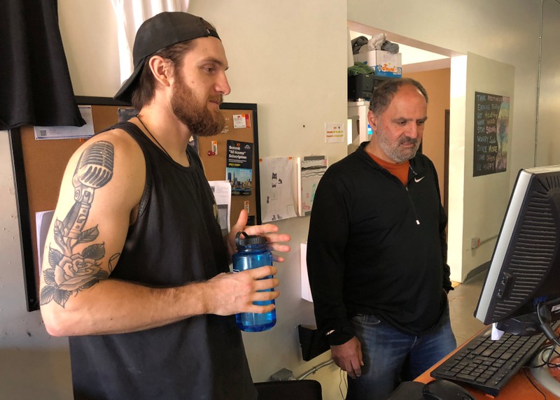 Employee Jason Etchingham and co-owner of FLEX, George Mardigian, look over reservations at his gym in Oakland