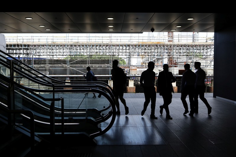 FILE PHOTO: People walk past the Crossrail construction site in the financial district of Canary Wharf in London