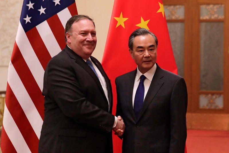 U.S. Secretary of State Mike Pompeo shakes hands with Chinese Foreign Minister Wang Yi as they pose for photographs at the Great Hall of the People in Beijing