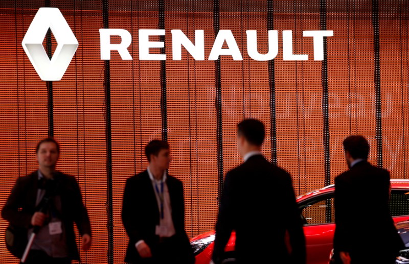 FILE PHOTO: Visitors walk past a Renault logo on the car maker's booth during the second media day of the 86th International Motor Show in Geneva