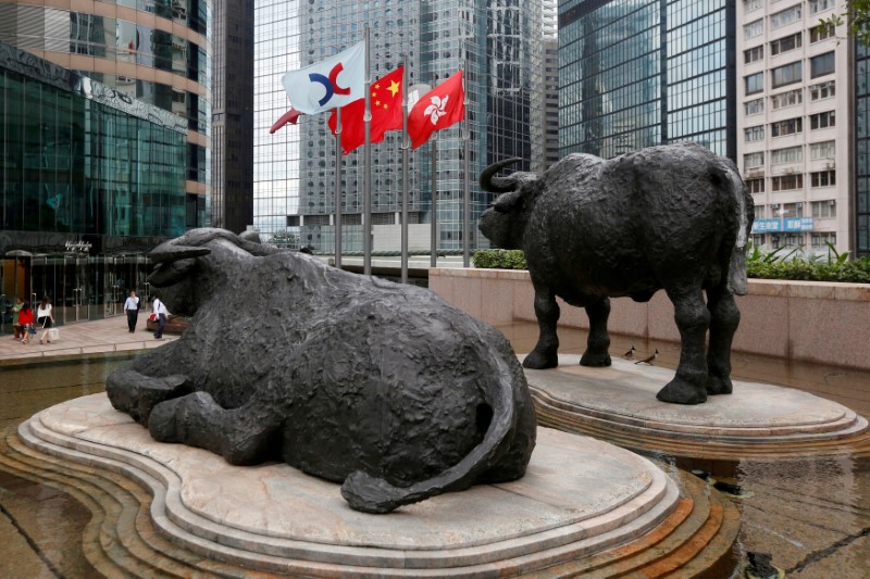 FILE PHOTO: Hong Kong Exchanges flag, Chinese national flag and Hong Kong flag are hoisted outside Hong Kong Stocks Exchange