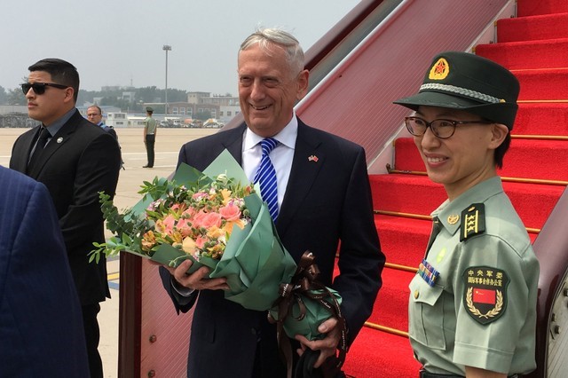U.S. Defense Secretary Jim Mattis receives a bouquet upon arrival at an airport in Beijing