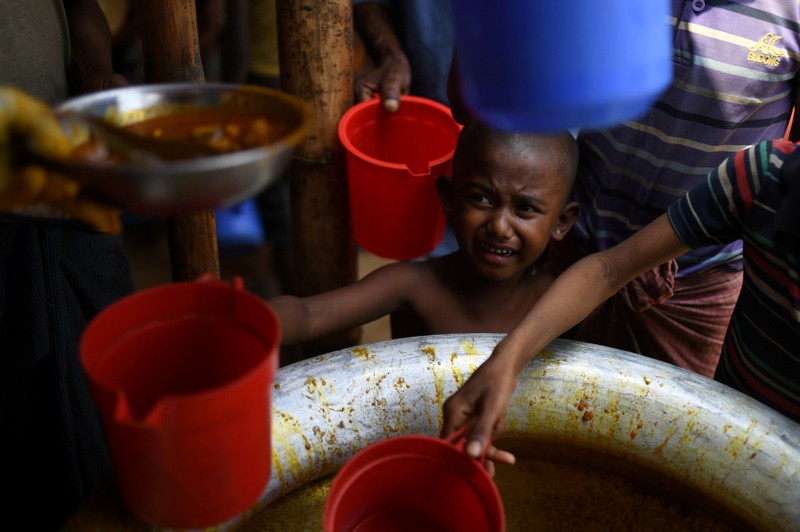 FILE PHOTO: FILE PHOTO: Rohingya refugee child waits for rations