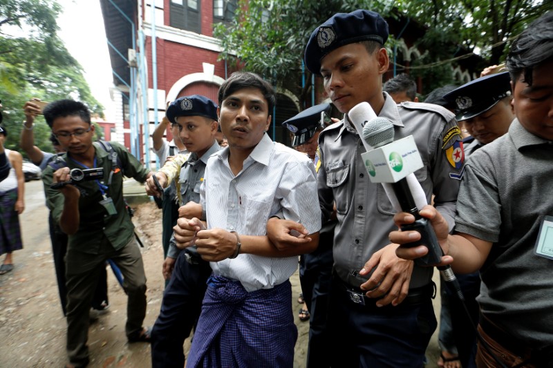 Detained Reuters journalist Kyaw Soe Oo is escorted by police while leaving Insein court in Yangon