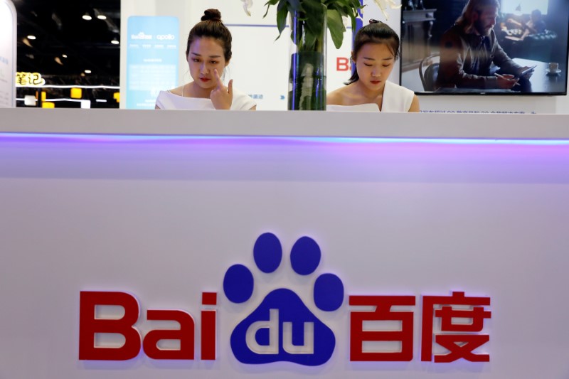 Members of staff work at the Baidu booth during Global Mobile Internet Conference (GMIC) at the National Convention in Beijing