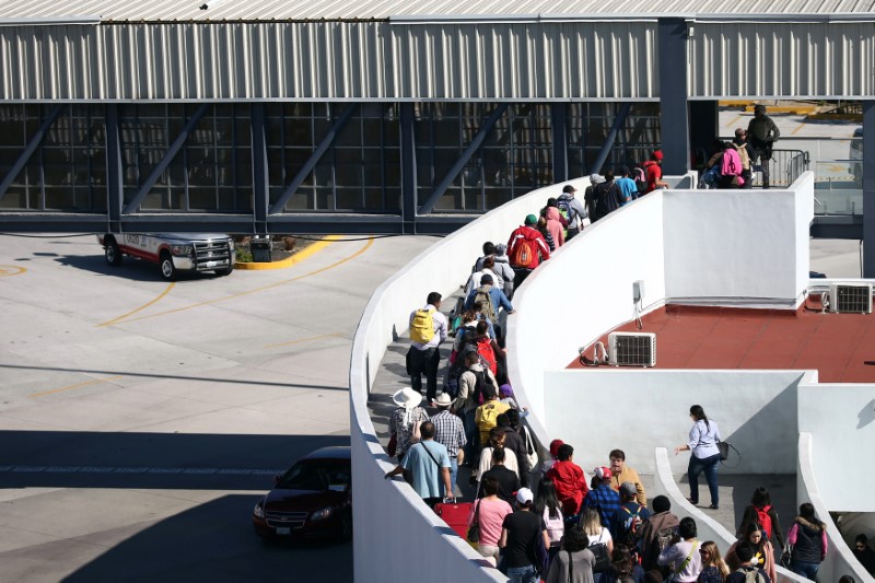 Members of a caravan of migrants from Central America, enter the United States border and customs facility, where they are expected to apply for asylum, in Tijuana