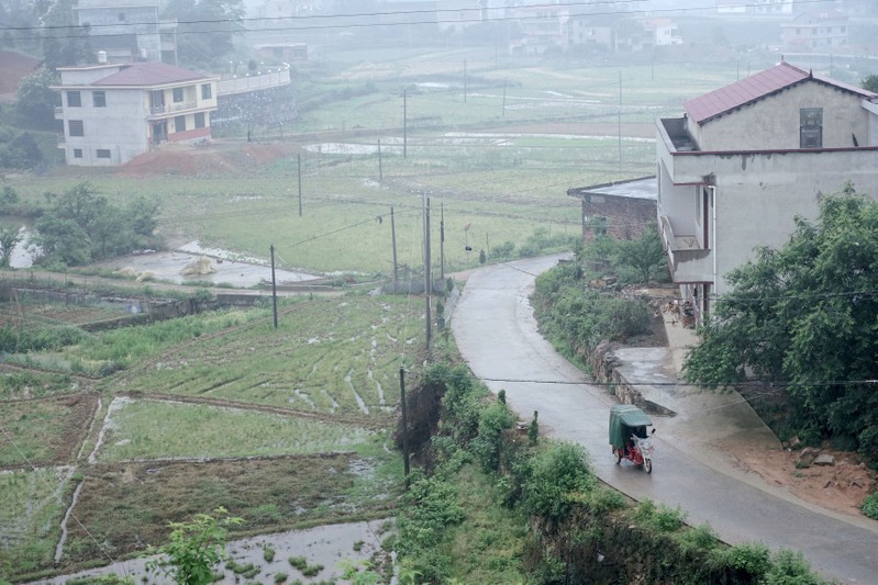 Man rides past houses at Furong village