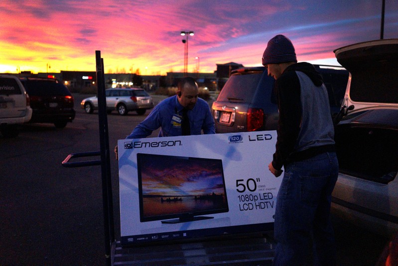 FILE PHOTO: A Walmart employee helps a customer load a 50
