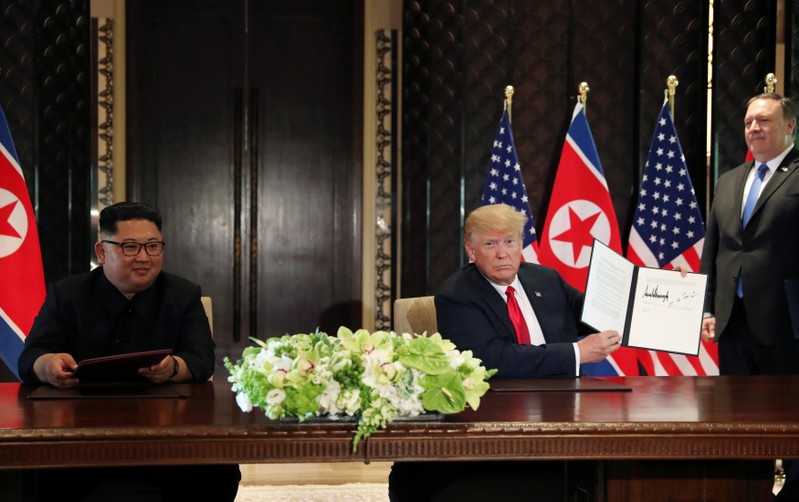FILE PHOTO: U.S. President Donald Trump shows the document, that he and North Korea's leader Kim Jong Un signed at their summit in Singapore