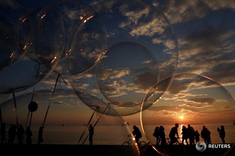 People are seen through balloons as they make their way at the seaside promenade of the northern port city of Thessaloniki