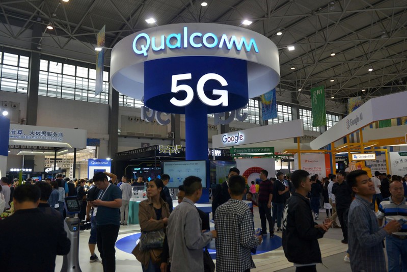 FILE PHOTO: Visitors are seen by a booth of Qualcomm Inc at the China International Big Data Industry Expo in Guiyang