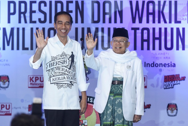 Indonesian President Joko Widodo and his running mate for the 2019 presidential election Islamic cleric Ma'ruf Amin wave after registering for the election at the General Election Commission in Jakarta