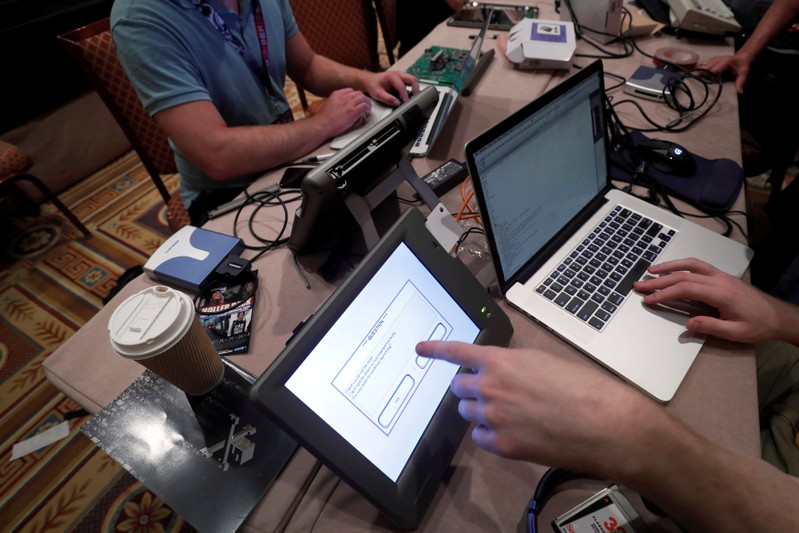 FILE PHOTO: Hackers try to access and alter data from an electronic poll books in a Voting Machine Hacking Village during the Def Con hacker convention in Las Vegas