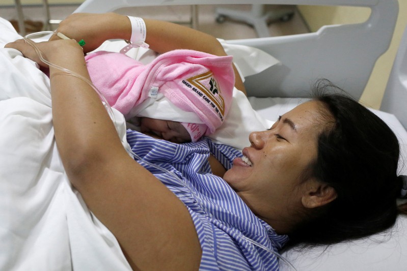 Pan Ei Mon, the wife of detained Reuters journalist Wa Lone, embraces her new born baby girl Thet Htar Angel in her hospital room in Yangon
