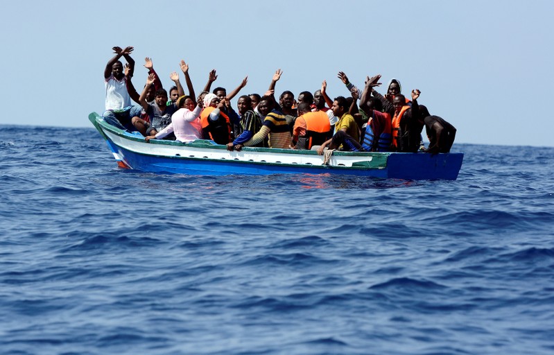 Migrants on a wooden boat react as they wait to be rescued by SOS Mediterranee organisation and Doctors Without Borders during a search and rescue (SAR) operation with the MV Aquarius rescue ship in the Mediterranean Sea