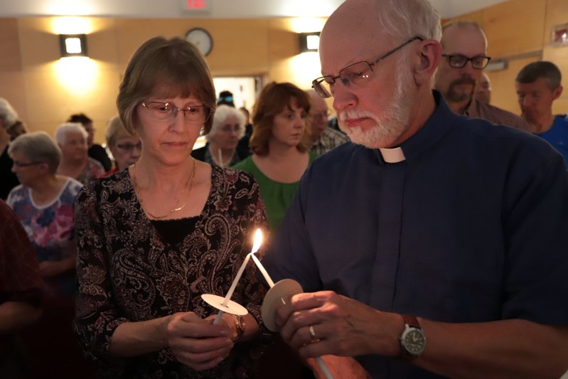 Participants light candles in a vigil at the St. John the Evangelist Anglican Church in Fredericton for the fallen in a fatal shooting in Fredericton