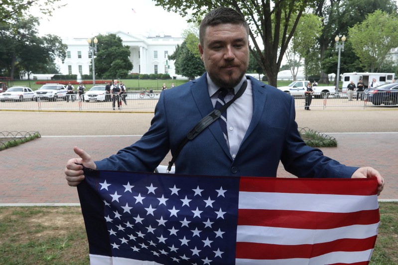 White nationalist leader Jason Kessler holds a flag across from the White House in Washington