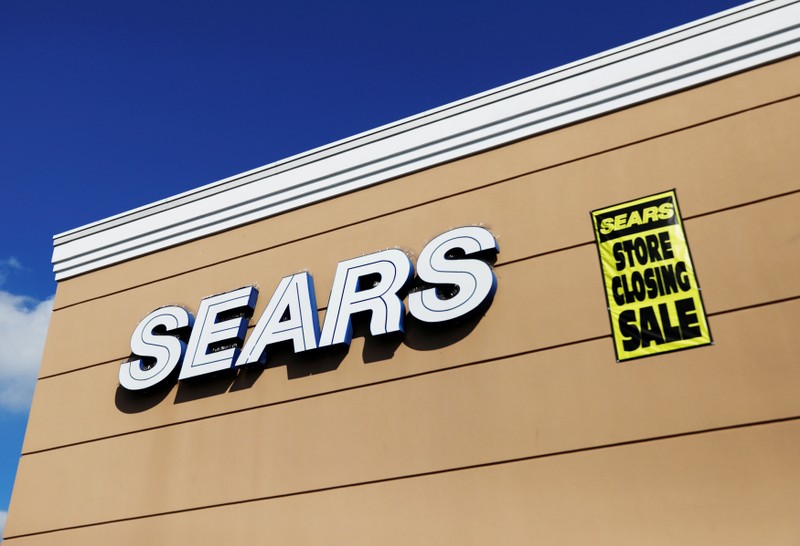 FILE PHOTO: A store closing sale sign is posted next to a Sears logo in New Hyde Park, New York