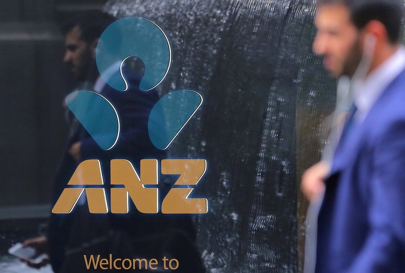 FILE PHOTO: A pedestrian is reflected in the window of a branch of the Australia and New Zealand Banking Group (ANZ) in central Sydney