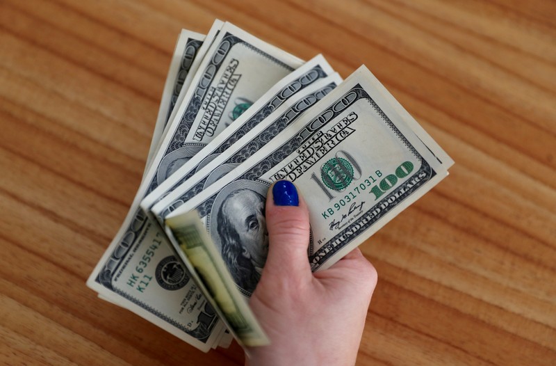 A woman shows U.S. dollar bills at her home in Buenos Aires