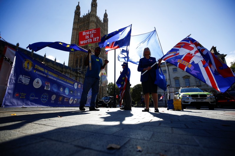 Anti-brexit protestors wave flags outside the Houses of Parliament in London