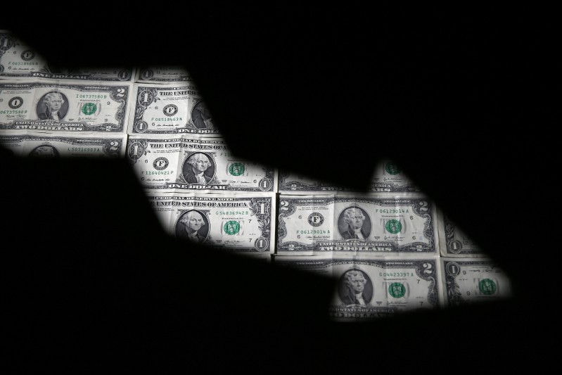 Dollar banknotes are seen through printed stock graph in this illustration