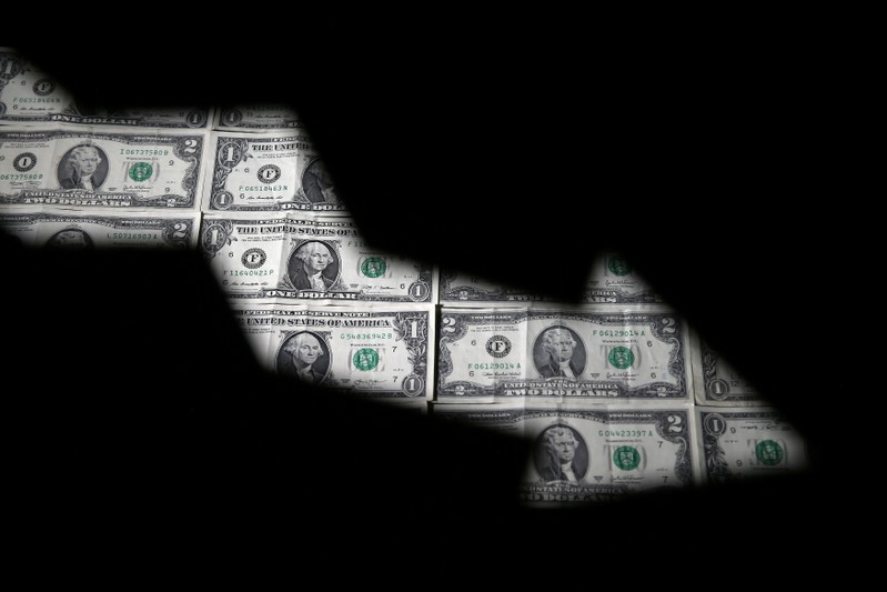 FILE PHOTO: Dollar banknotes are seen through printed stock graph in this illustration