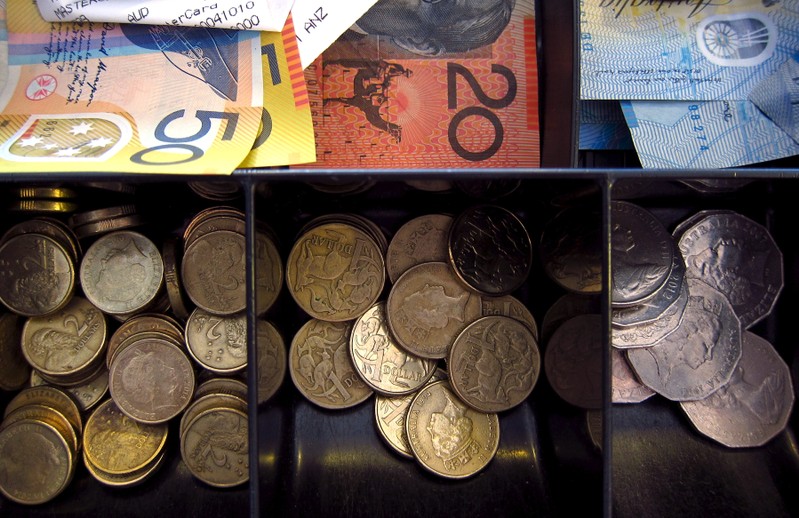 FILE PHOTO - Australian dollar notes and coins can be seen in a cash register at a store in Sydney