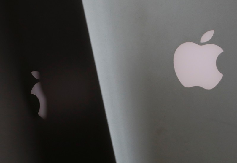 Apple company logos are seen as two MacBooks stand next to each other in an office in Vienna