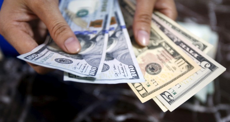 FILE PHOTO: An employee checks U.S. dollar bank-notes at a bank in Hanoi, Vietnam