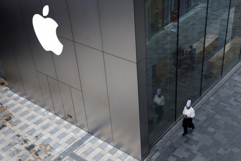 FILE PHOTO: Chef walks past an Apple store in Beijing