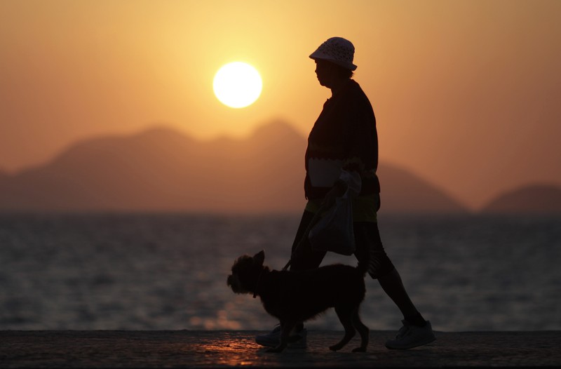 An elderly lady walks with her dog in Copacabana in Rio de Janeiro
