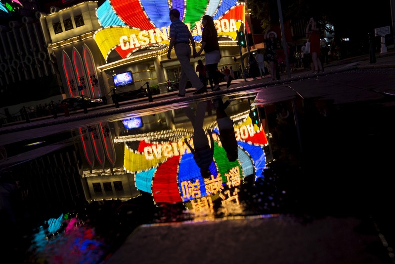 FILE PHOTO: Mainland Chinese visitors walk in front of Casino Lisboa, owned by SJM Holdings, in Macau, China