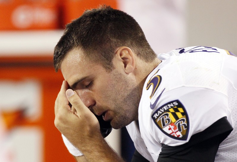 Joe Flacco talks on the phone on the sidelines in the fourth quarter in their NFL football game against the Denver Broncos in Denver