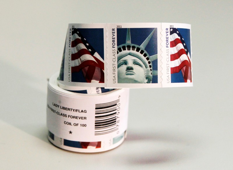 FILE PHOTO: A coil of 100 new USA First Class postage stamps, bearing an image of the Statue of Liberty and U.S. flags, is shown in Washington