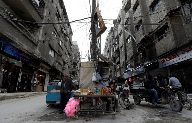 A man sells goods along a street in Ein Terma, a district of eastern Ghouta
