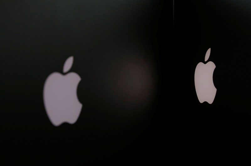 Apple company logos are seen as two MacBooks stand next to each other in an office in Vienna