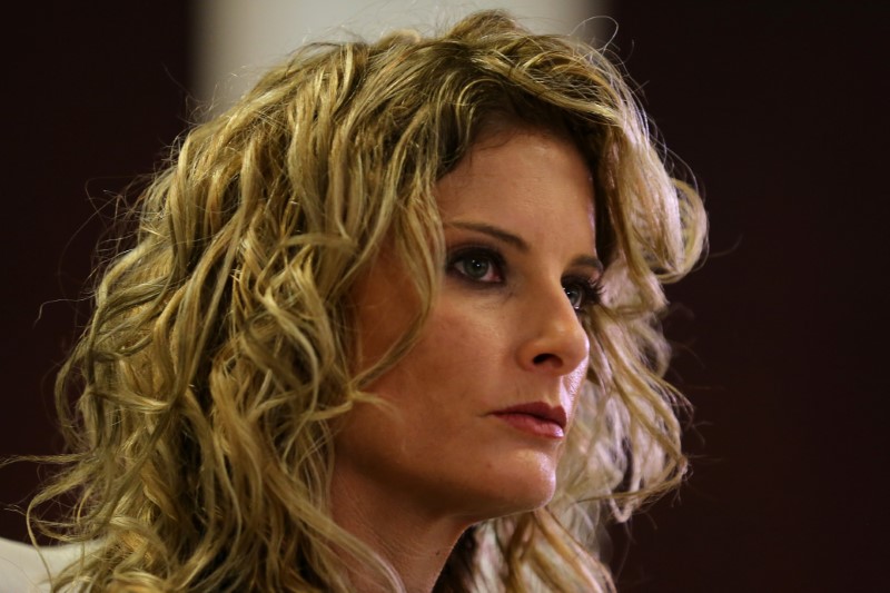 Summer Zervos listens as her attorney Gloria Allred speaks during a news conference announcing the filing of a lawsuit against President-elect Donald Trump in Los Angeles