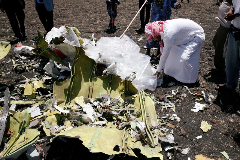 A Saudi man who's brother died in the Ethiopian Airlines Flight ET 302 plane crash, touches a debris after a commemoration ceremony at the scene of the crash, near the town of Bishoftu, southeast of Addis Ababa